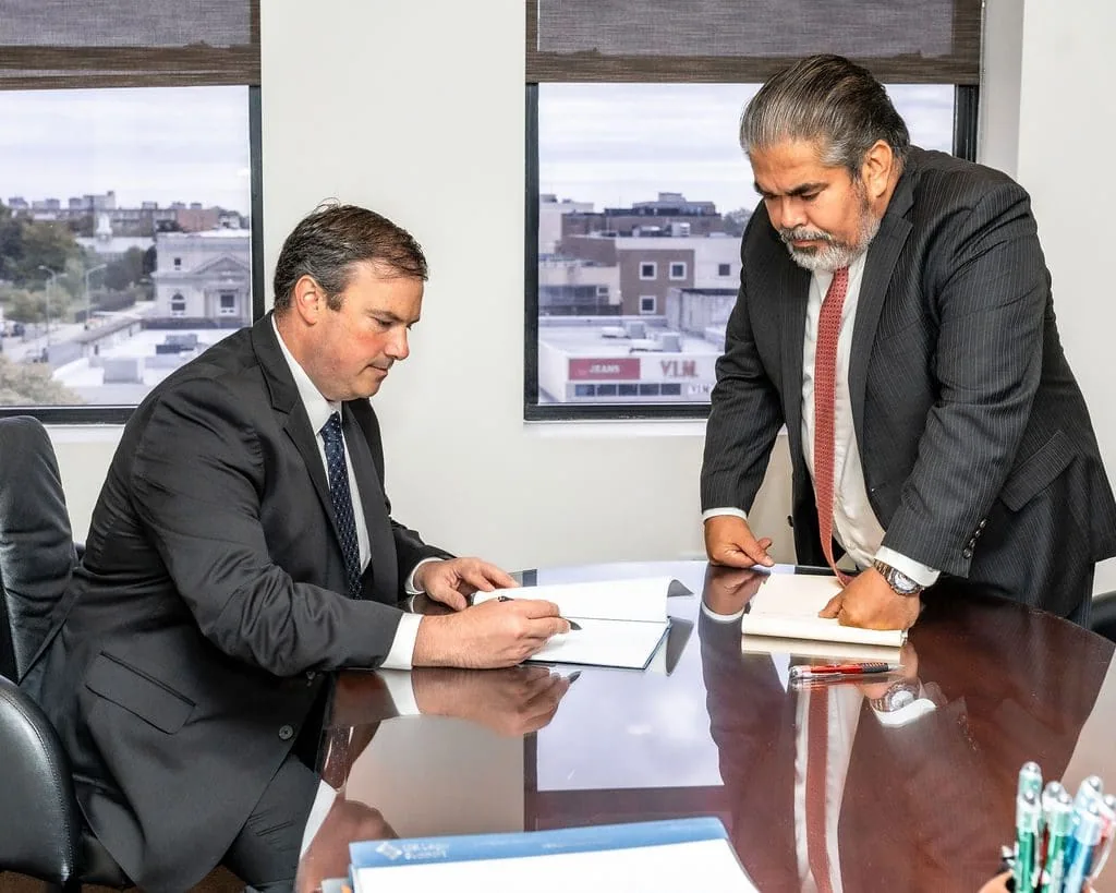 Matthew Voelpel y César Valdebenito revisan un expediente en la sala de reuniones de Hempstead.